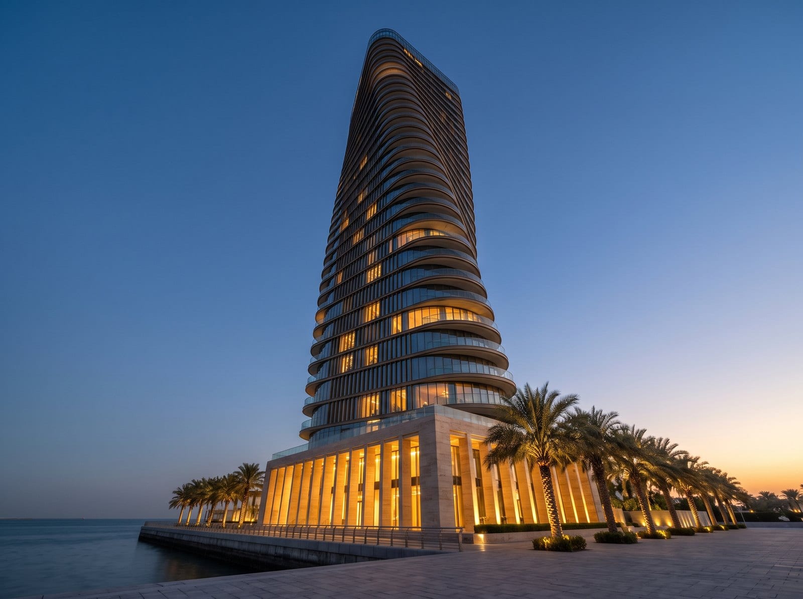 Altair seen from the water at dusk, its floors turning as they rise above the lit podium